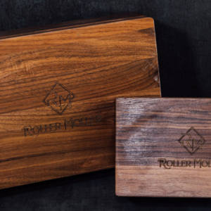 Compact and Grand solid walnut boxes with closed engraved lids, shown together without accessories.